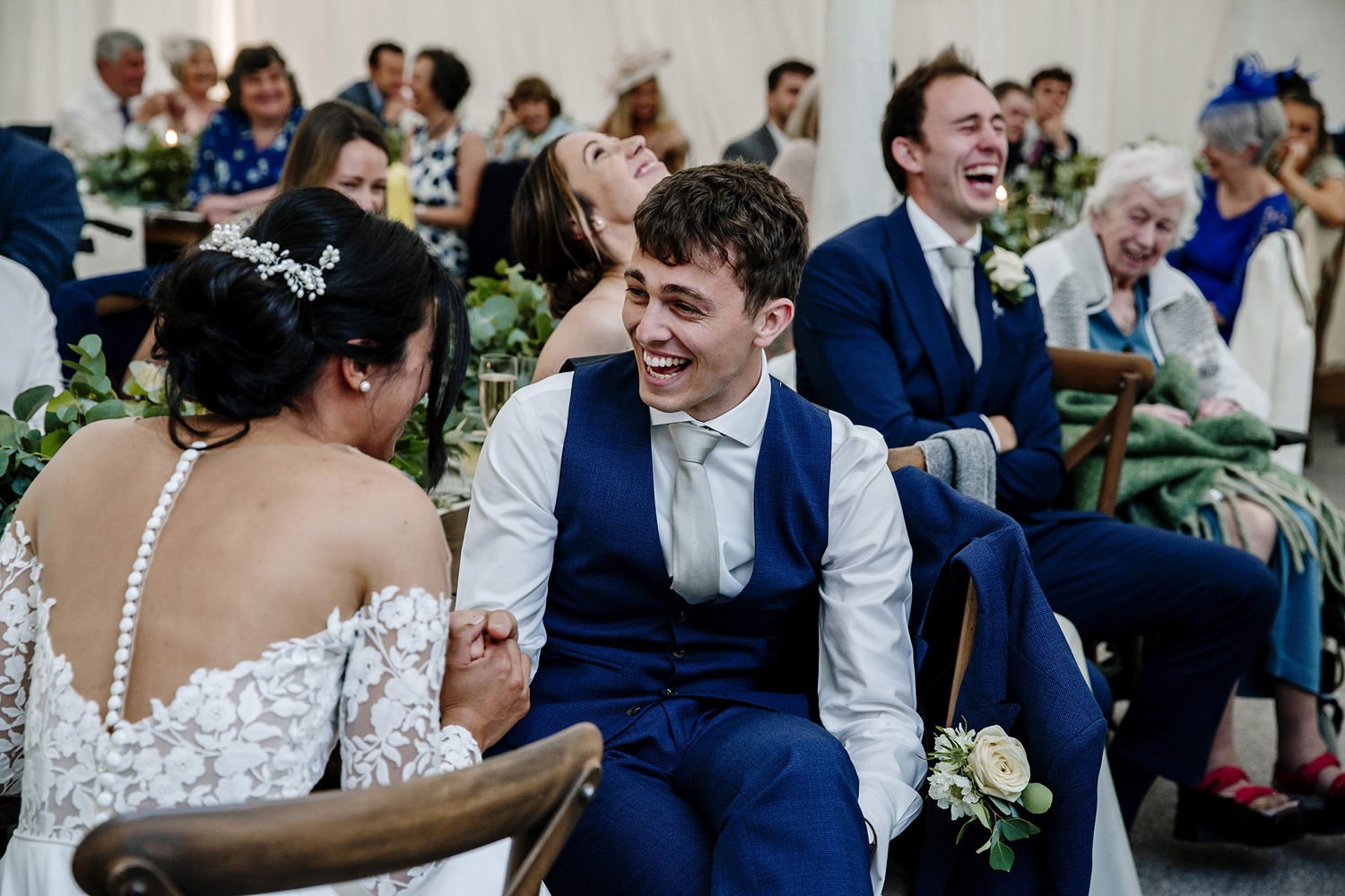 Bride and groom laughing at mum's speech