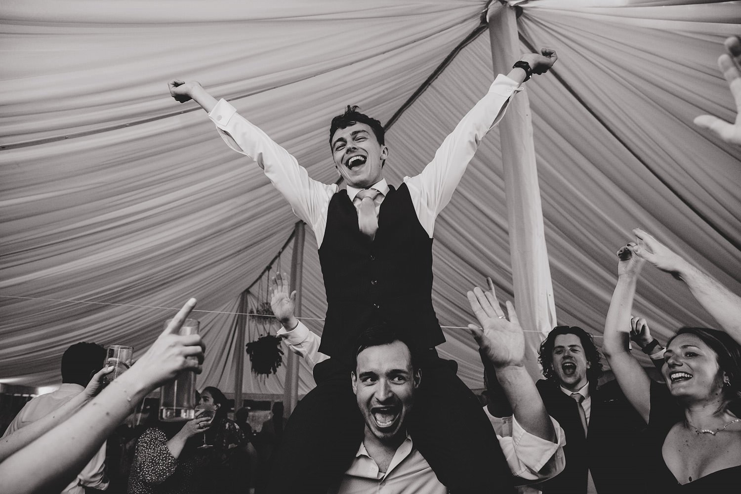 Happy groom on shoulders on dancefloor