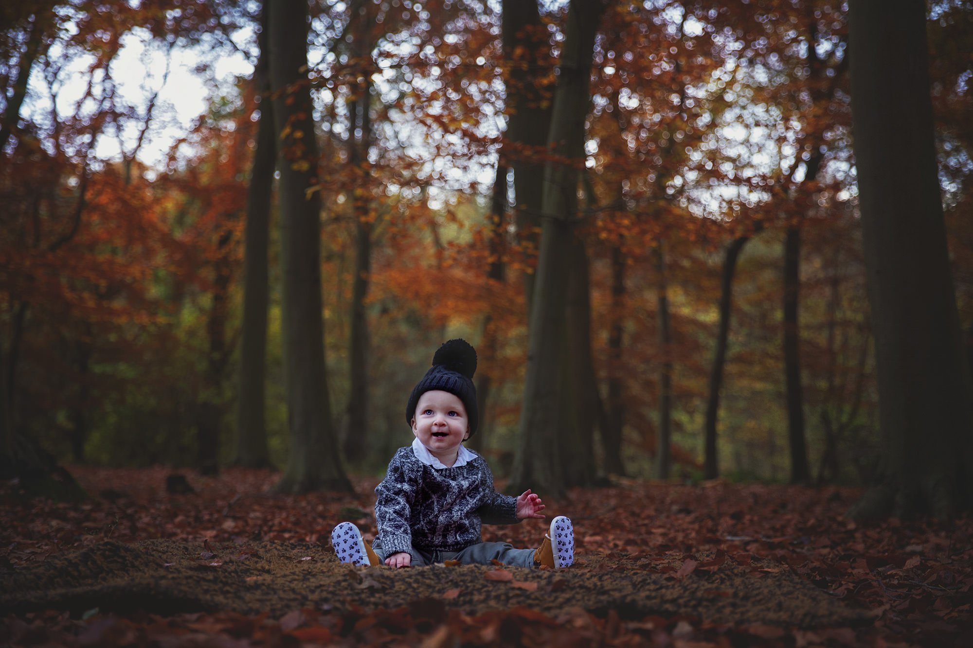 Toddler in bobble hat in Autumn
