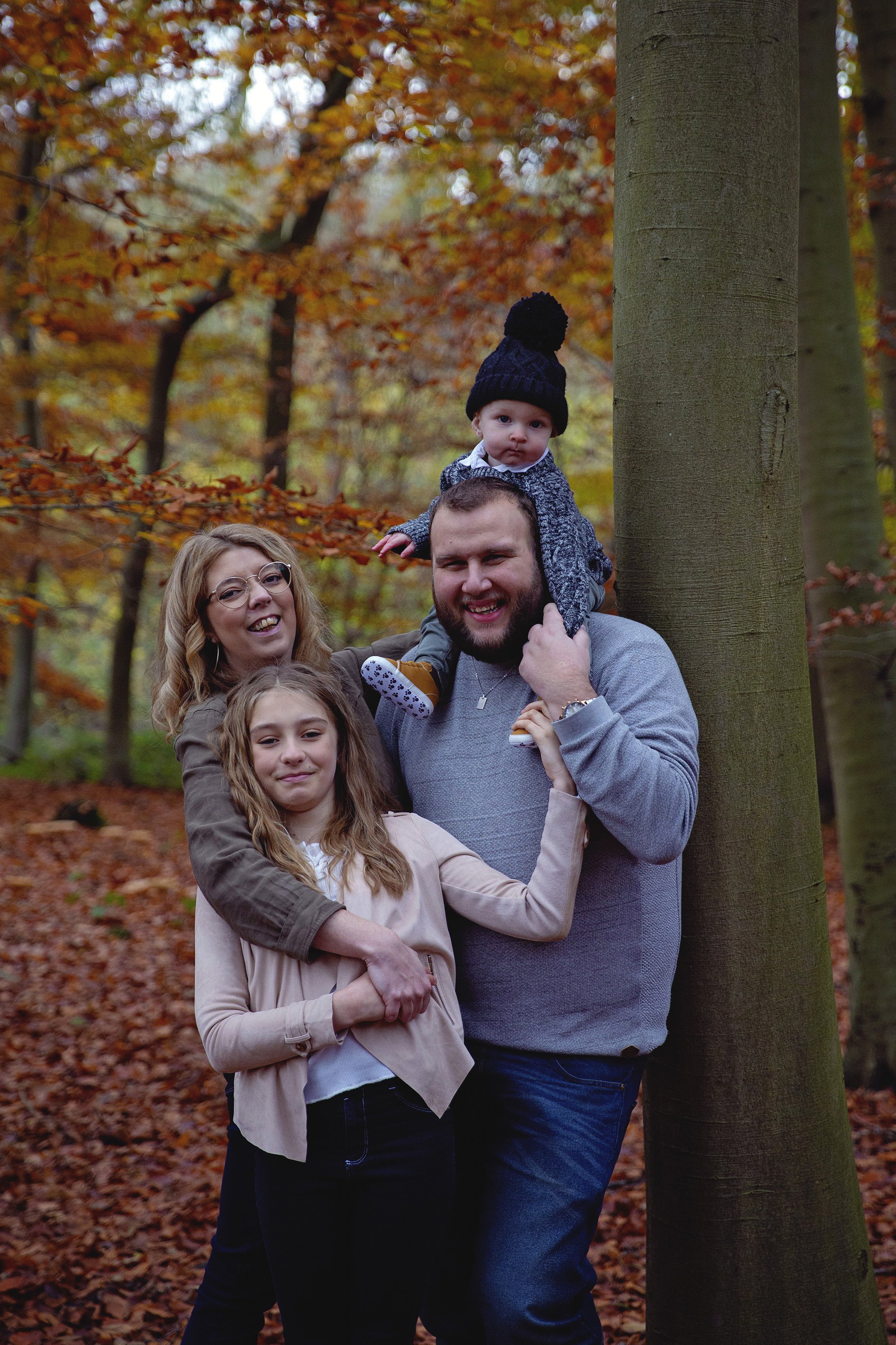 Family hugging in Autumn leaves