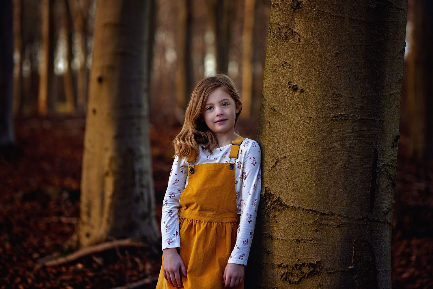 Girl posing against a tree in winter