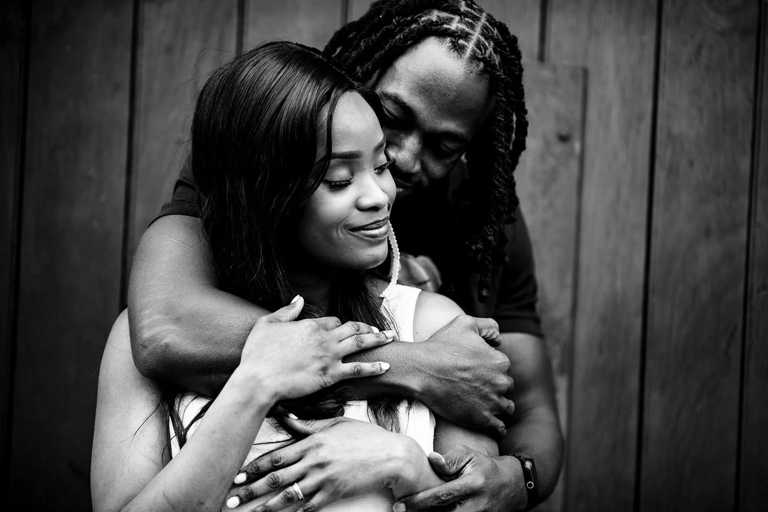 A couple embracing each other with gentle smiles in black and white.