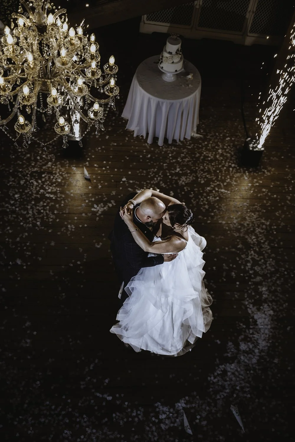 Bride and groom dancing alone surrounded by confetti