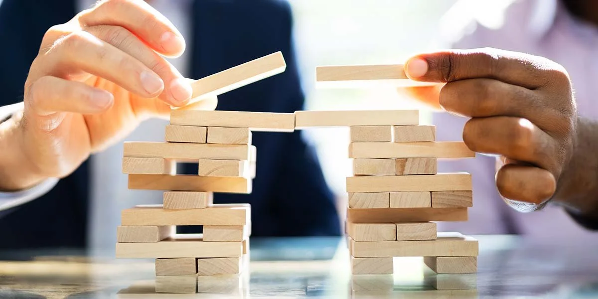 Image of coworkers playing Jenga to represent “Bringing Compassion into Networks, Roles, and Routines” for the Center for Compassionate Leadership blog post, "How To Apply Compassionate Leadership."