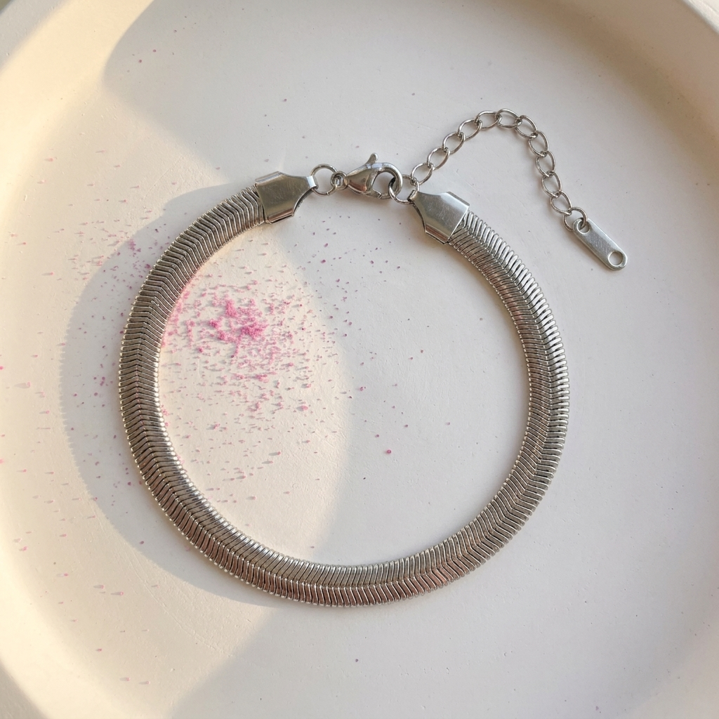 Wide silver herringbone chain bracelet on white surface with fuchsia pink powder - stainless steel jewellery London - Kincha Designs