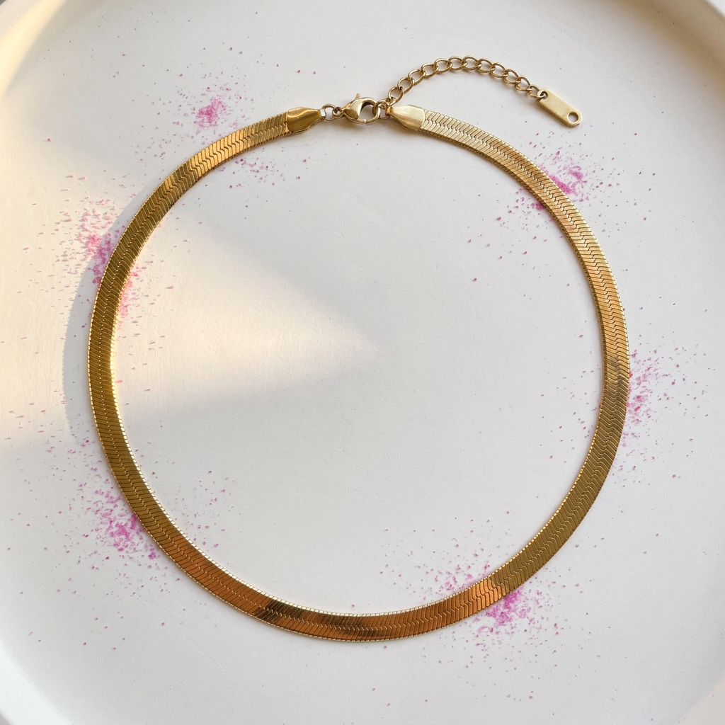 Slim gold herringbone chain necklace on white surface with fuchsia pink powder - stainless steel jewellery London - Kincha Designs