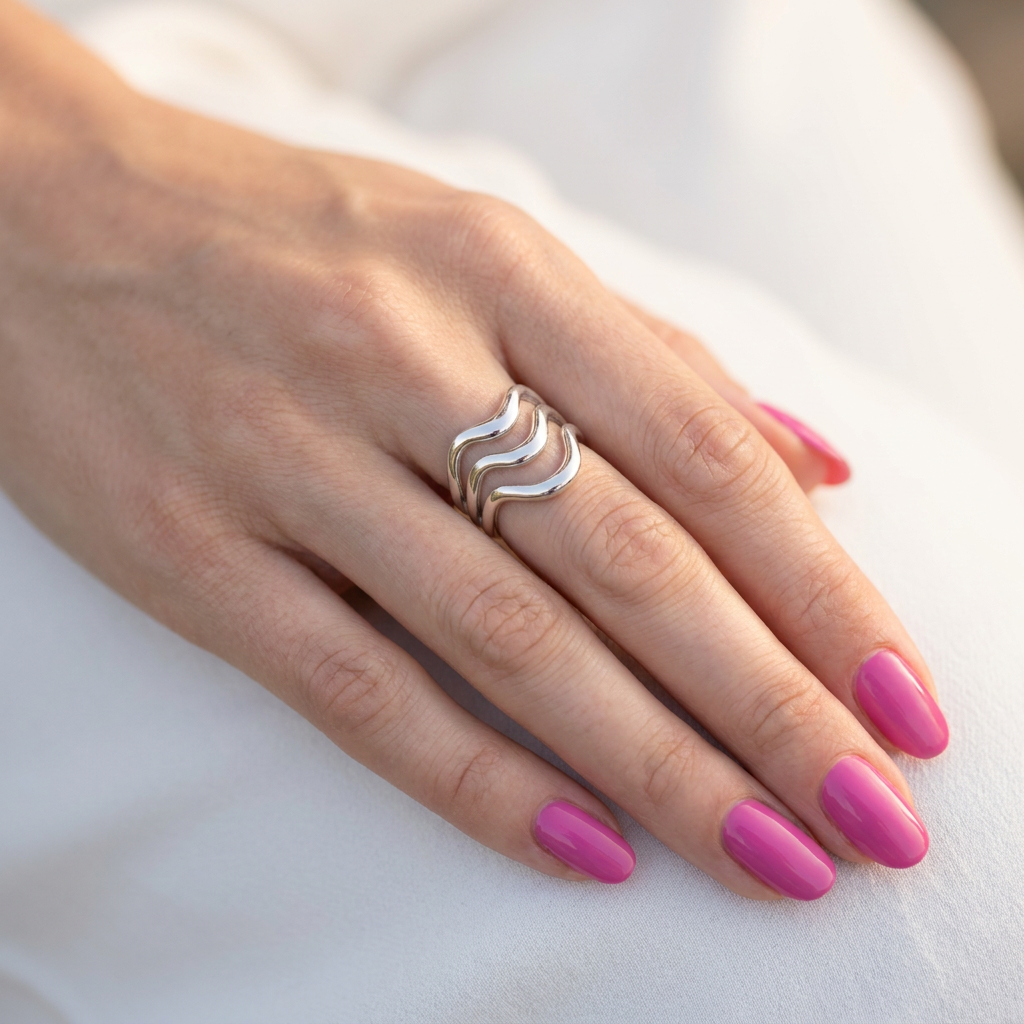Hand wearing silver wave stainless steel ring with pink nails - statement jewellery - Kincha Designs London