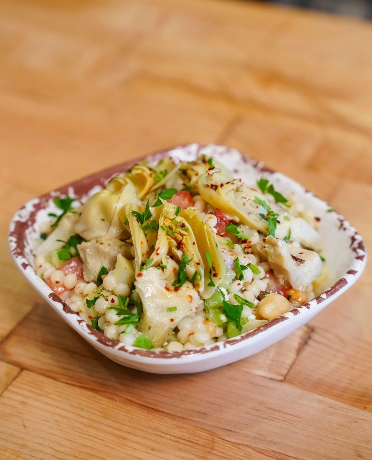 Couscous the food so nice they named it twice!⁠
⁠
Introducing our newest seasonal shared plate: Artichoke Couscous. Marinated artichokes, red onion, garbanzo, cucumber, tomato, parsley, feta, and pine nuts make for a refreshing cold salad that is as 