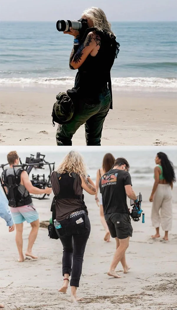 Photographers filming on a beach, with the ocean in the background and people walking along the shoreline.