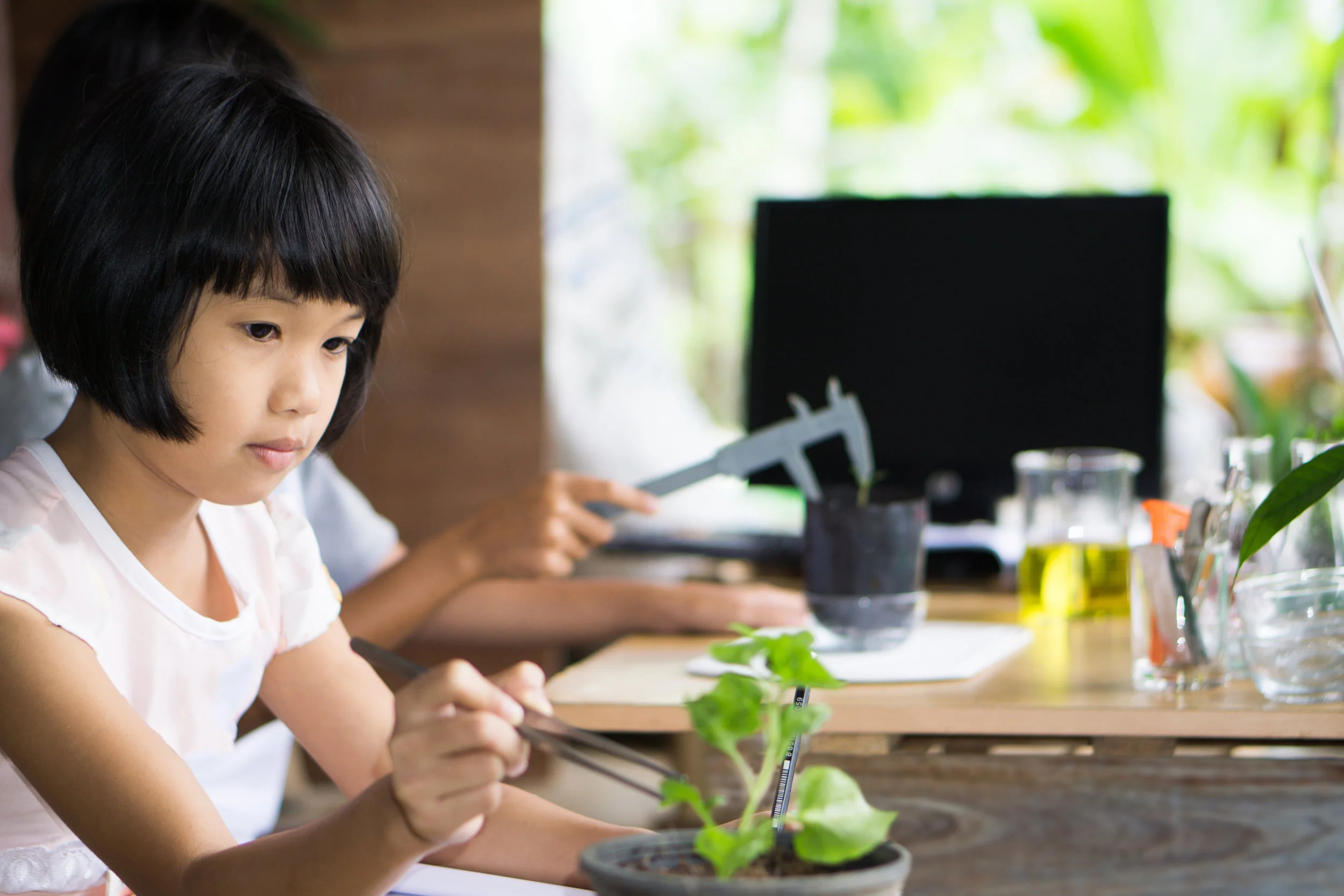 A girl in class with plant and tweesers.jpg