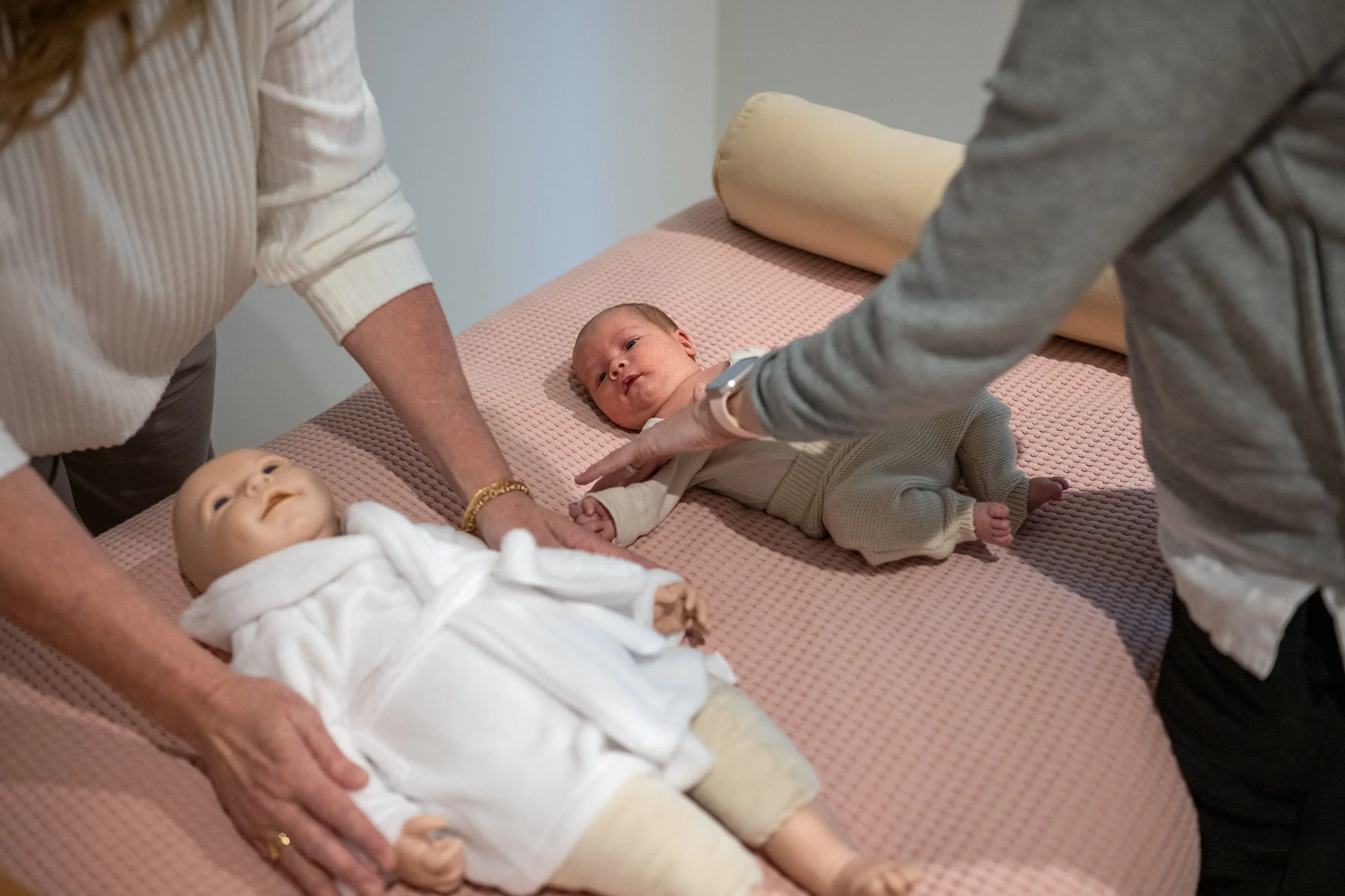 A mother learning house to perform baby massage in one of the Maternal and Infant Wellbeing Melbourne Mummy and Me massage sessions.