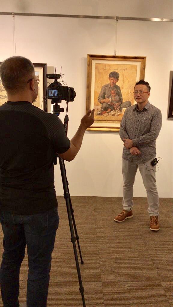 Wang Fei speaking at an interview during his exhibition