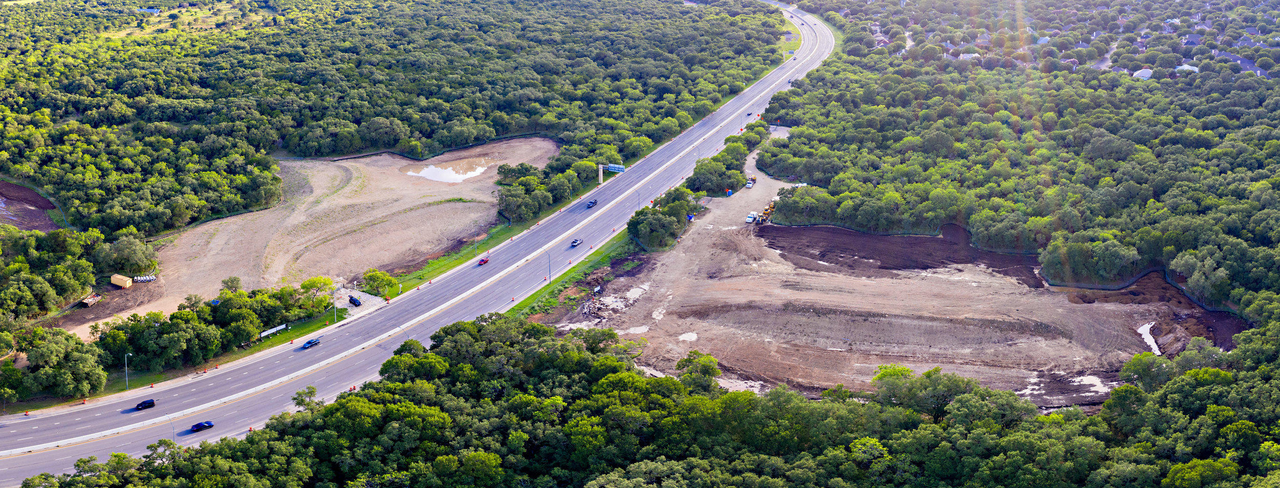 Drone imagery captured in June, 2019 by Justin Moore of Texas By Air . The soil berms that create the footing of the Land Bridge are currently being constructed. (North is the right side of this image.)