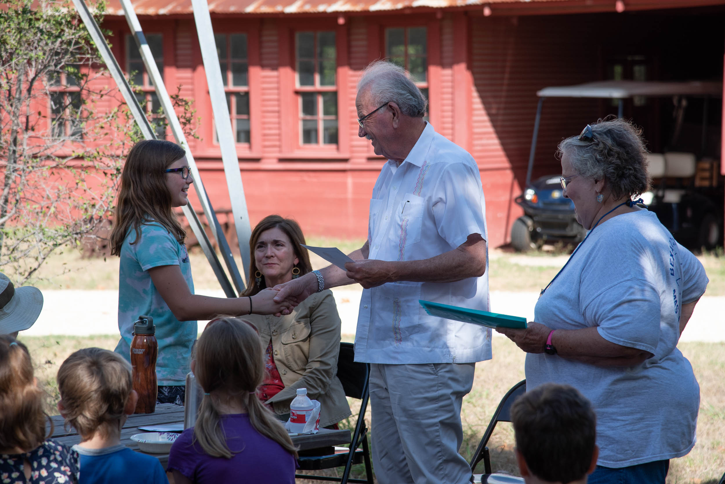 Phil Hardberger presents Arwen Bailey with her Junior Master Gardener Certification.
