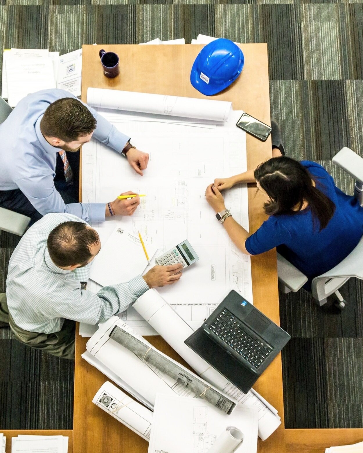 three-people-working-on-construction-drawings.jpg