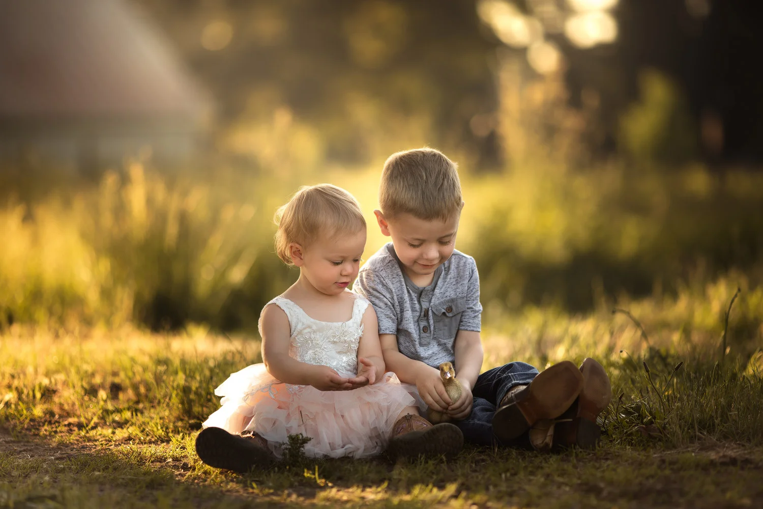 Young-Boy-Girl-Sitting-Grass-Duckling.jpg