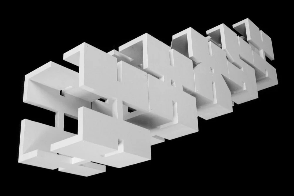 Modular wooden sculptures forming step-like letter blocks, each cube shown from angle.