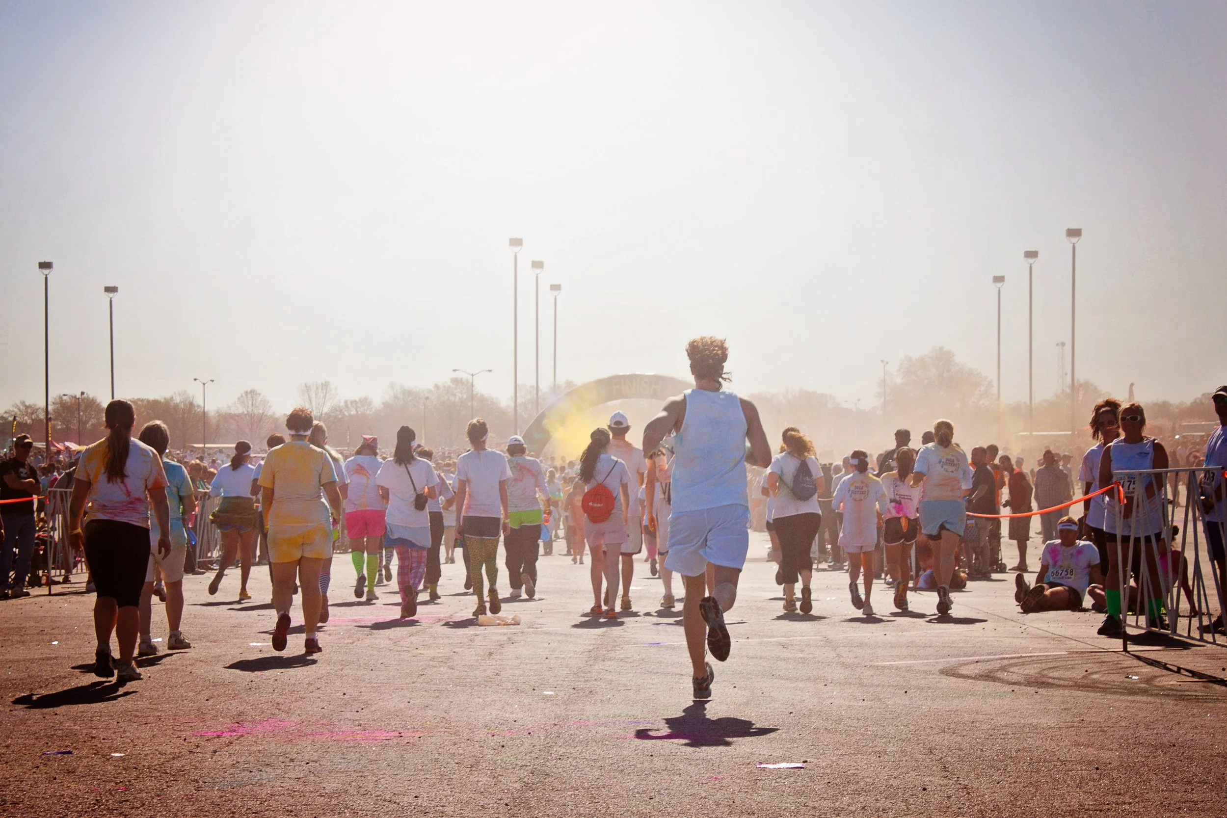 A diverse group of runners moving toward the finish line together during a community race at sunrise, symbolizing perseverance, unity, and Christlike love.