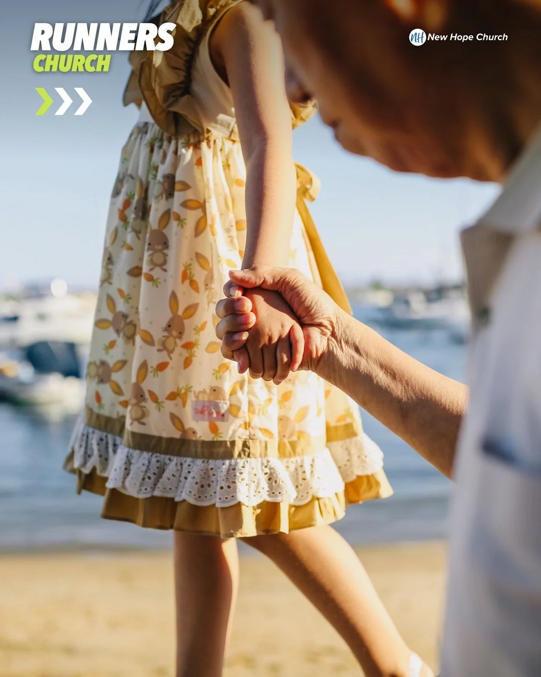 A grandfather holding a child’s hand while they walk together in warm daylight near the water.