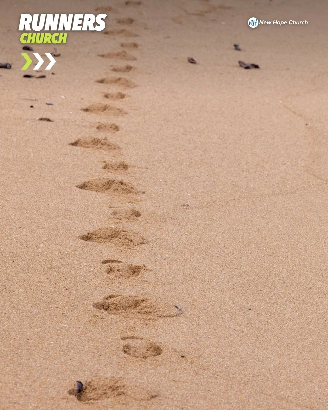 A single trail of footprints leads across clean sunlit sand toward the horizon