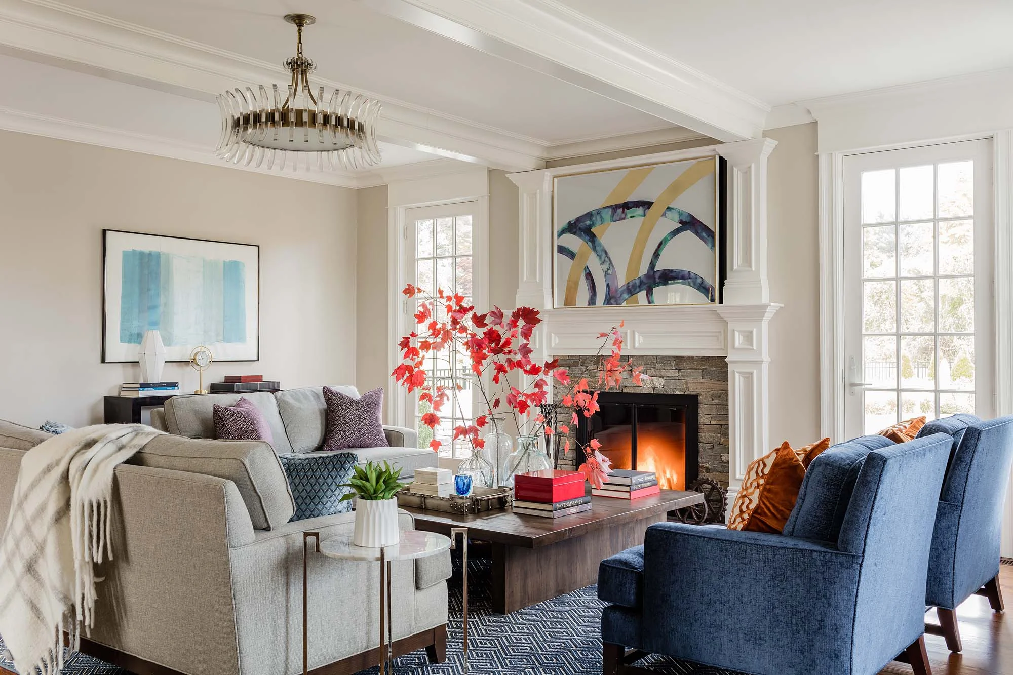 Living room with sofa, fireplace, wooden center table and artworks on wall, h, restoration hardware, verranzano bookcase, wood bookcase, kravet, pelham chair, currey and co, currey
