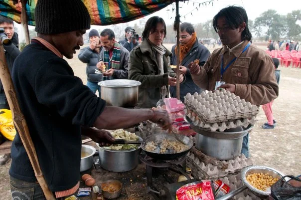 Arun (middle) and a member of another band, Minap, dig into a rare meal of eggs.