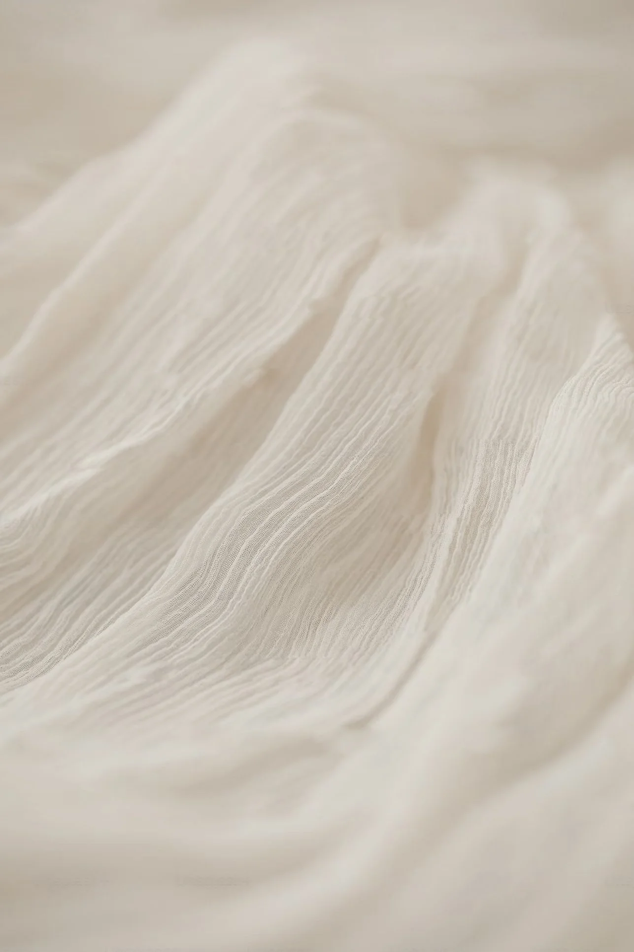 Close-up of textured beige fabric with visible weave and folds.