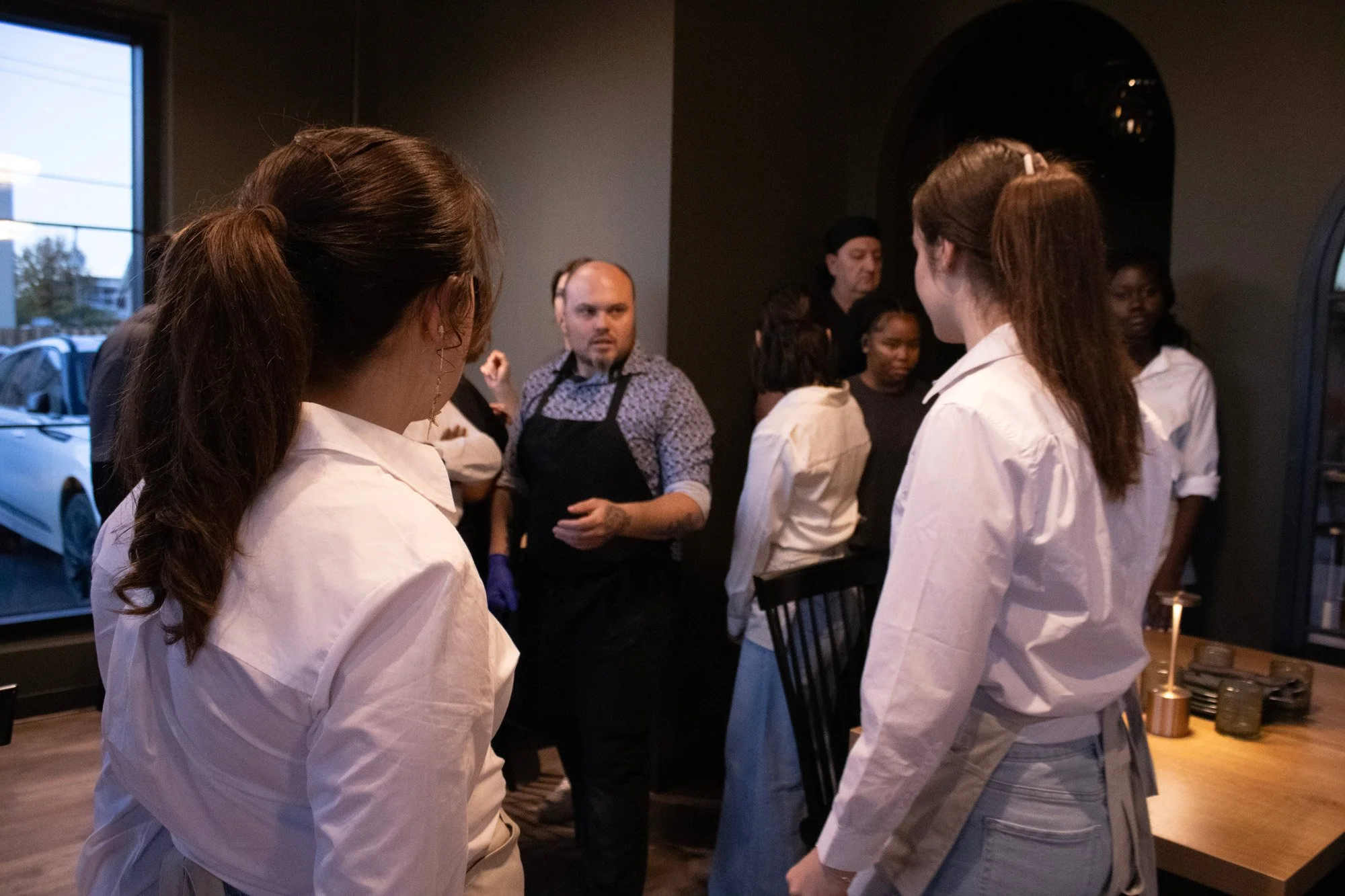 A candid shot of restaurant staff in a pre-shift meeting