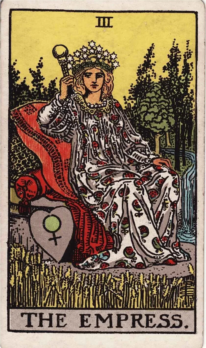 Tarot card titled 'The Empress' showing a woman with a crown of stars sitting on a throne outdoors, holding a scepter, with trees and a flowing stream in the background.