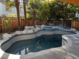 Custom swimming pool and raised spa with natural rock landscaping