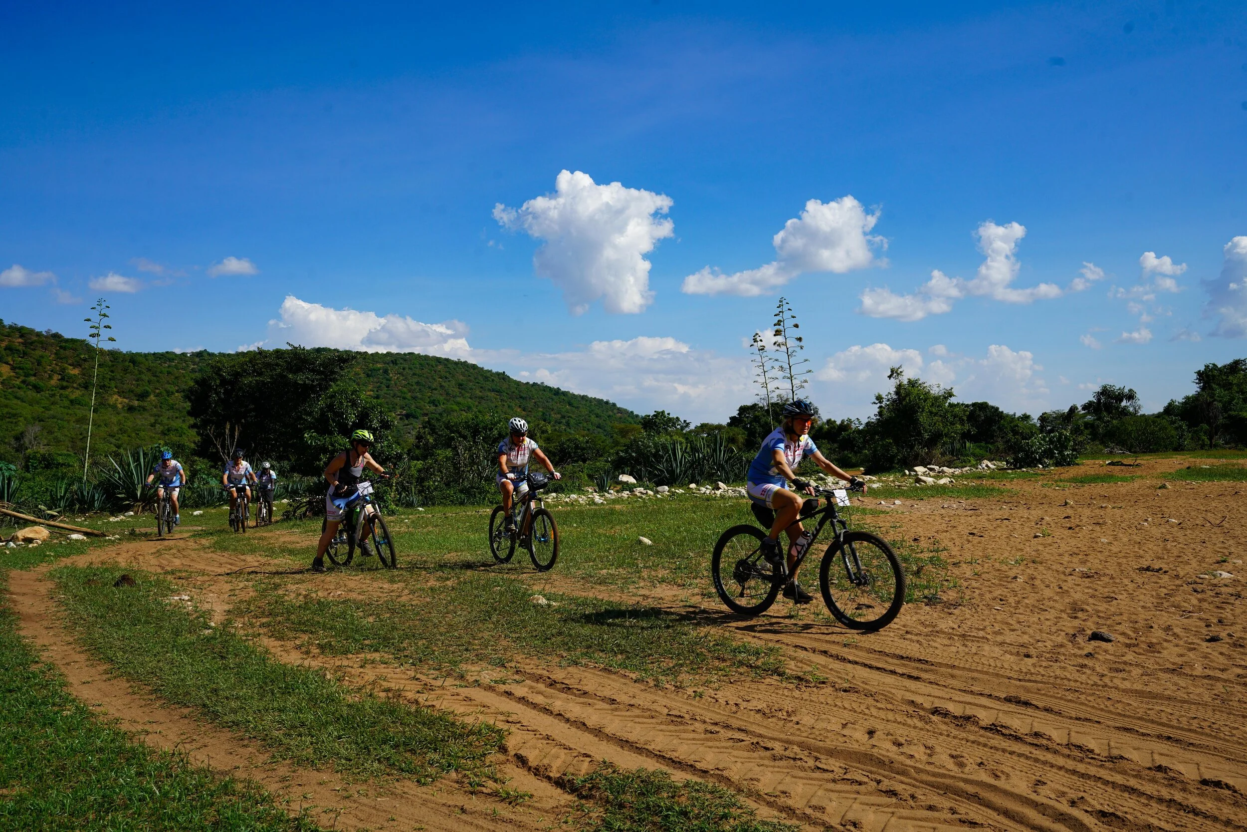  After lunch we’re back on the bikes and now rolling through the undulating Kenya high country.  The setting up here is different once again.  Dirt tracks, cooler temperatures, red earth, and no traffic or true signs of modern life.  