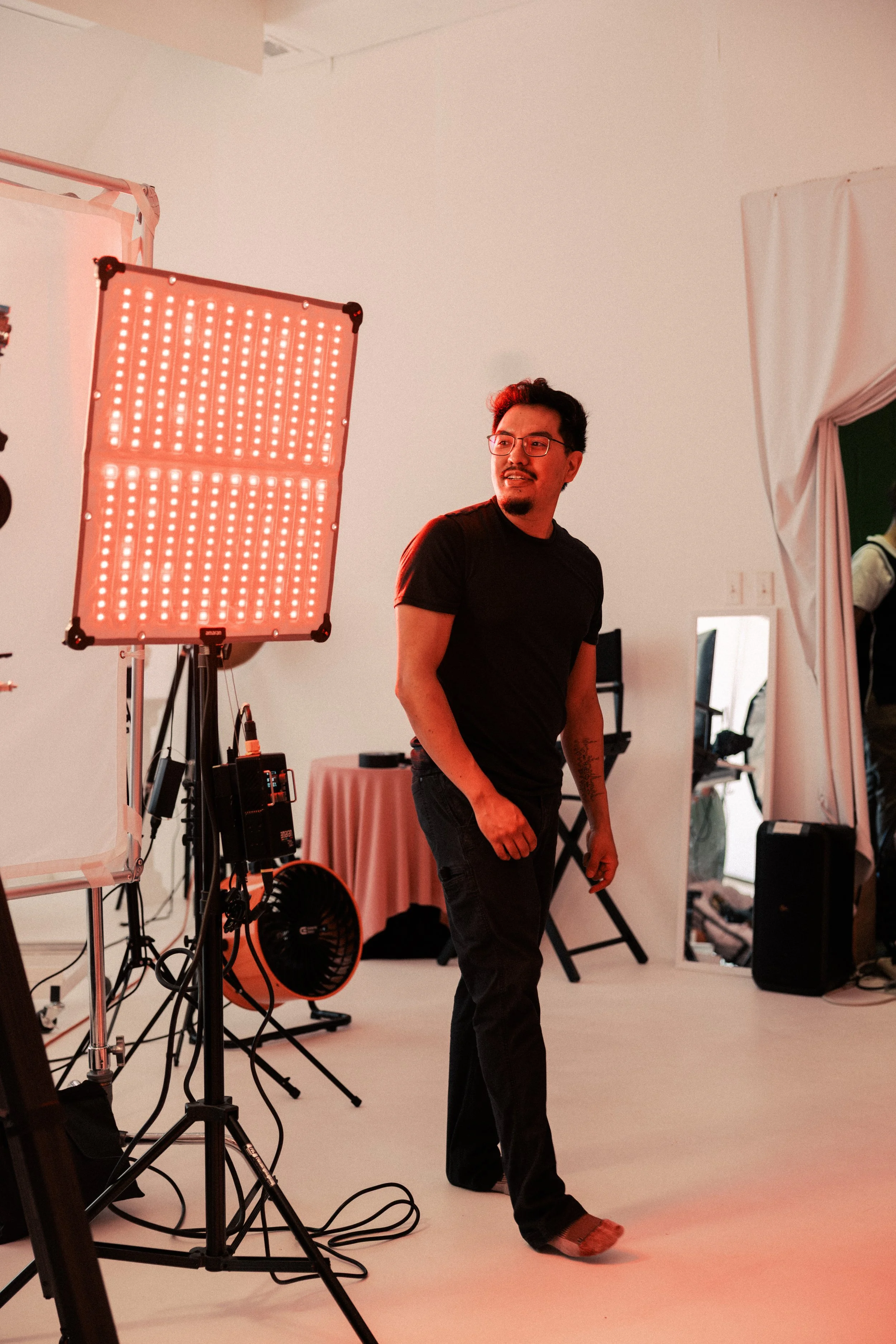 Professional video shoot setup with Director of Photography Tony Gonzales adjusting lighting during a brand video production in Dallas Fort Worth.