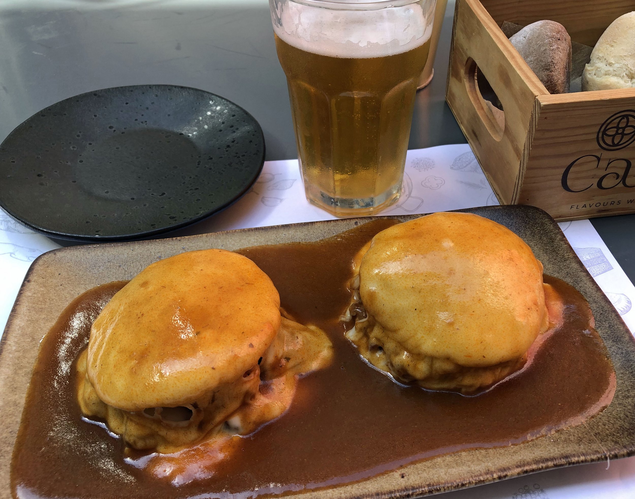 Francesinha, a tradtional Portuguese dish from Porto containing toasted bread, beef, sausages, ham and melted cheese served in a tomato-and-beer sauce. Loaded with flavor … and cholesterol.