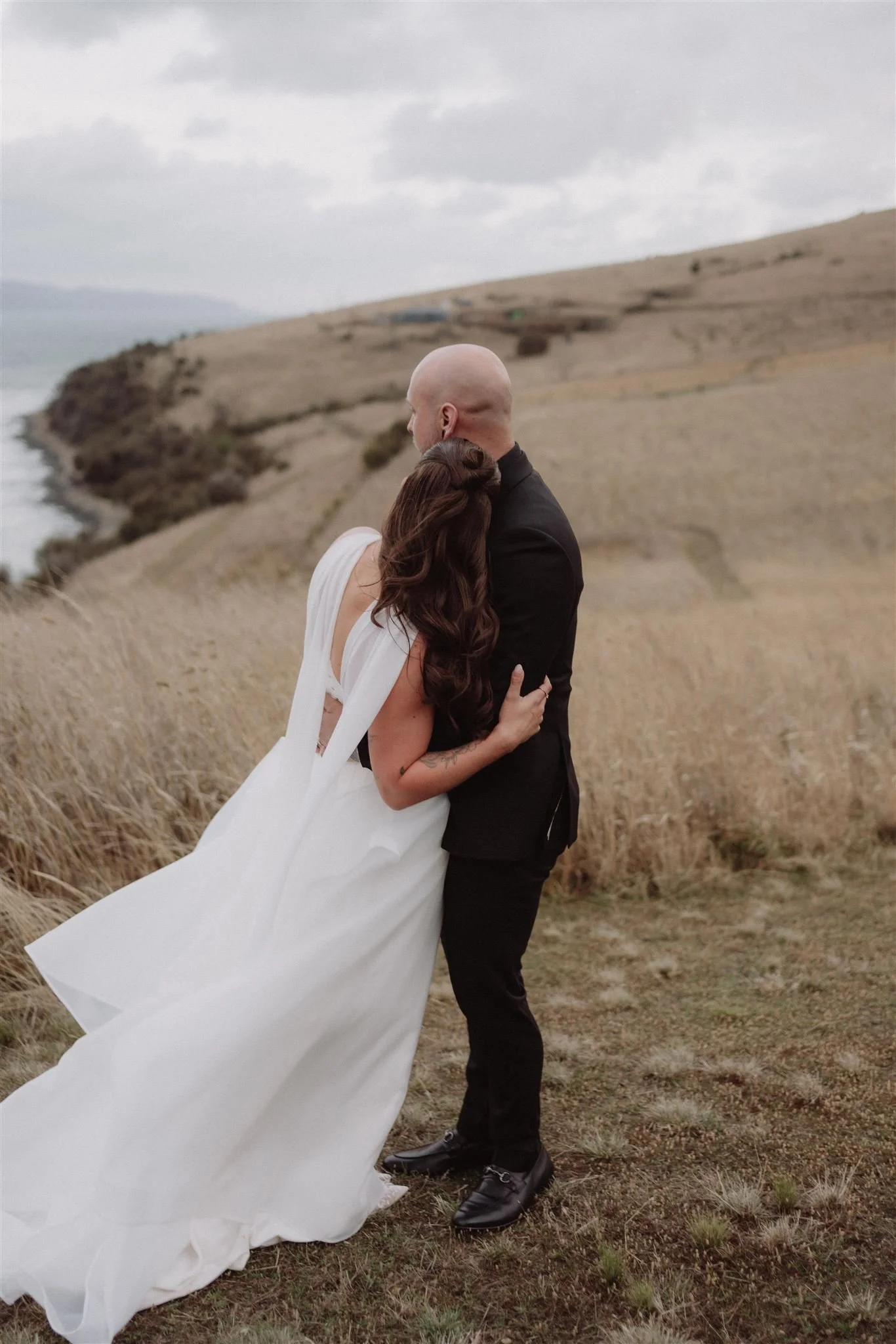 elopement couple hugging in front of coastal view in hobart tasmania