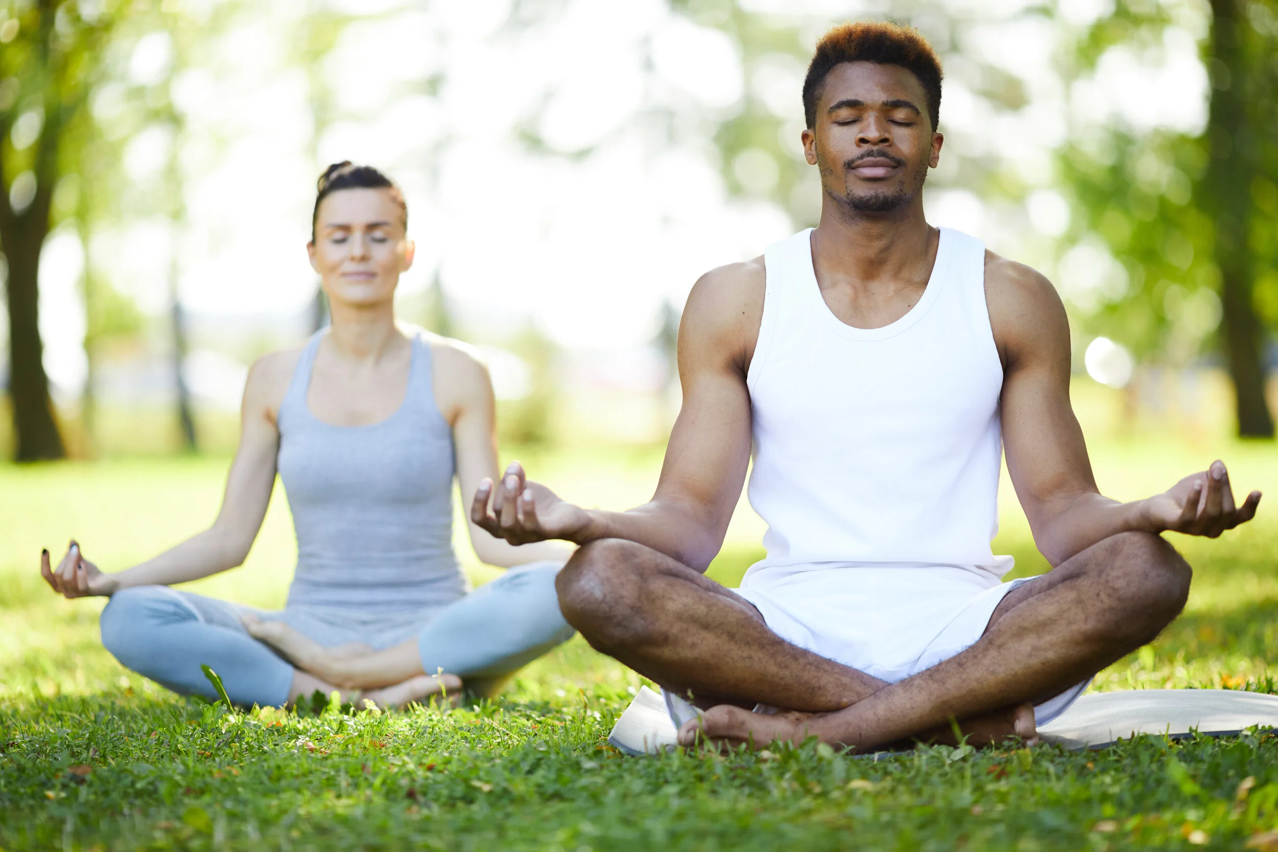 concentrated-yoga-students-meditating-in-park-4RFBVZ7.jpg