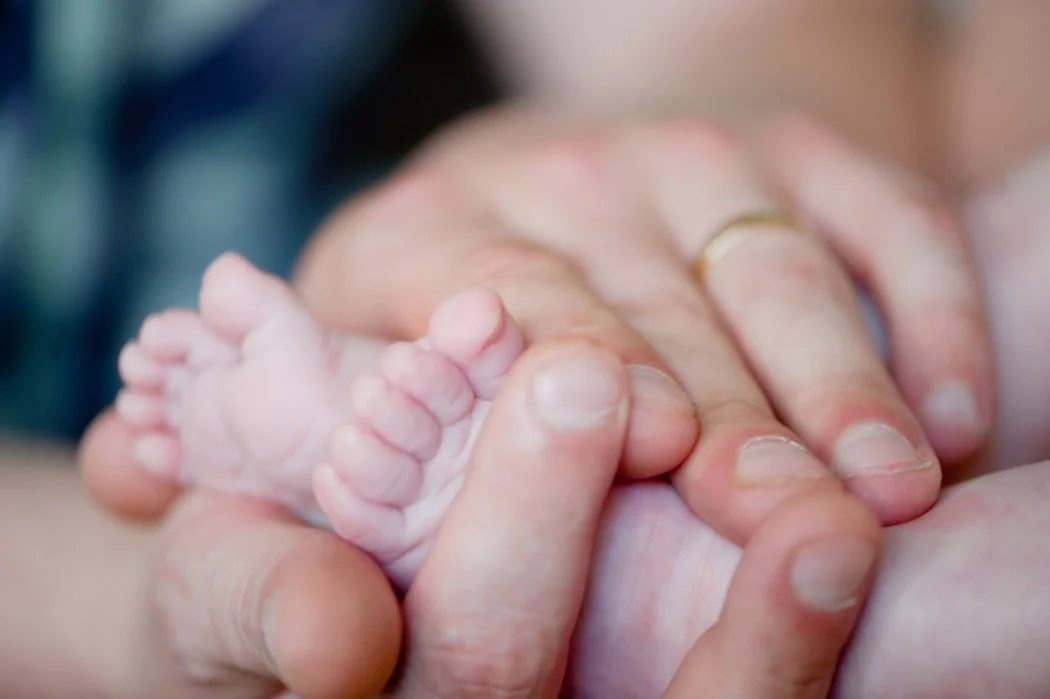 Closeup of baby feet in hands
