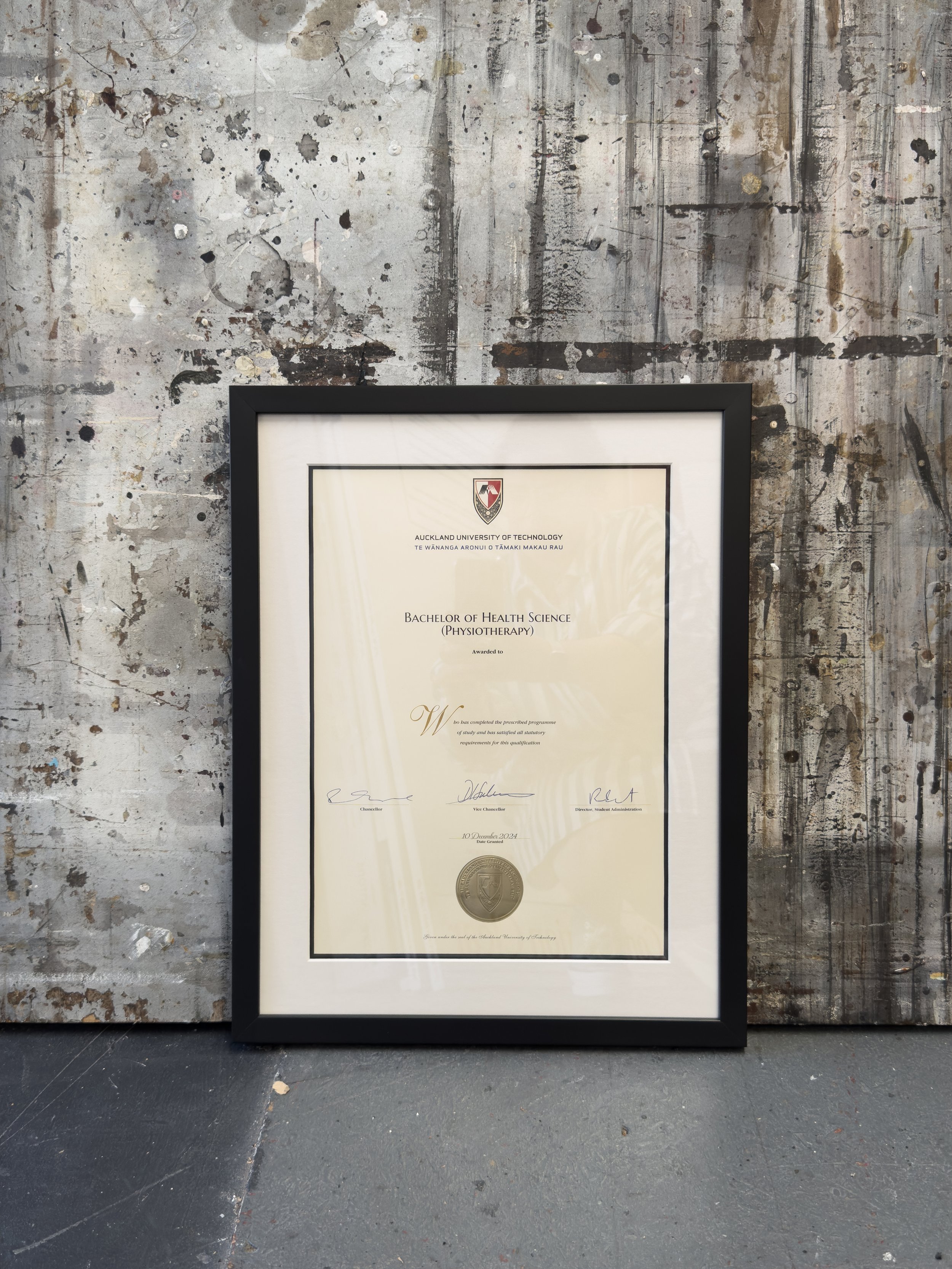 Framed diploma from Auckland University of Technology for a Bachelor of Health Science in Physiotherapy, with our standard degree frame around it. This is the black frame with double mat option, with a black inner mat and white top mat. 