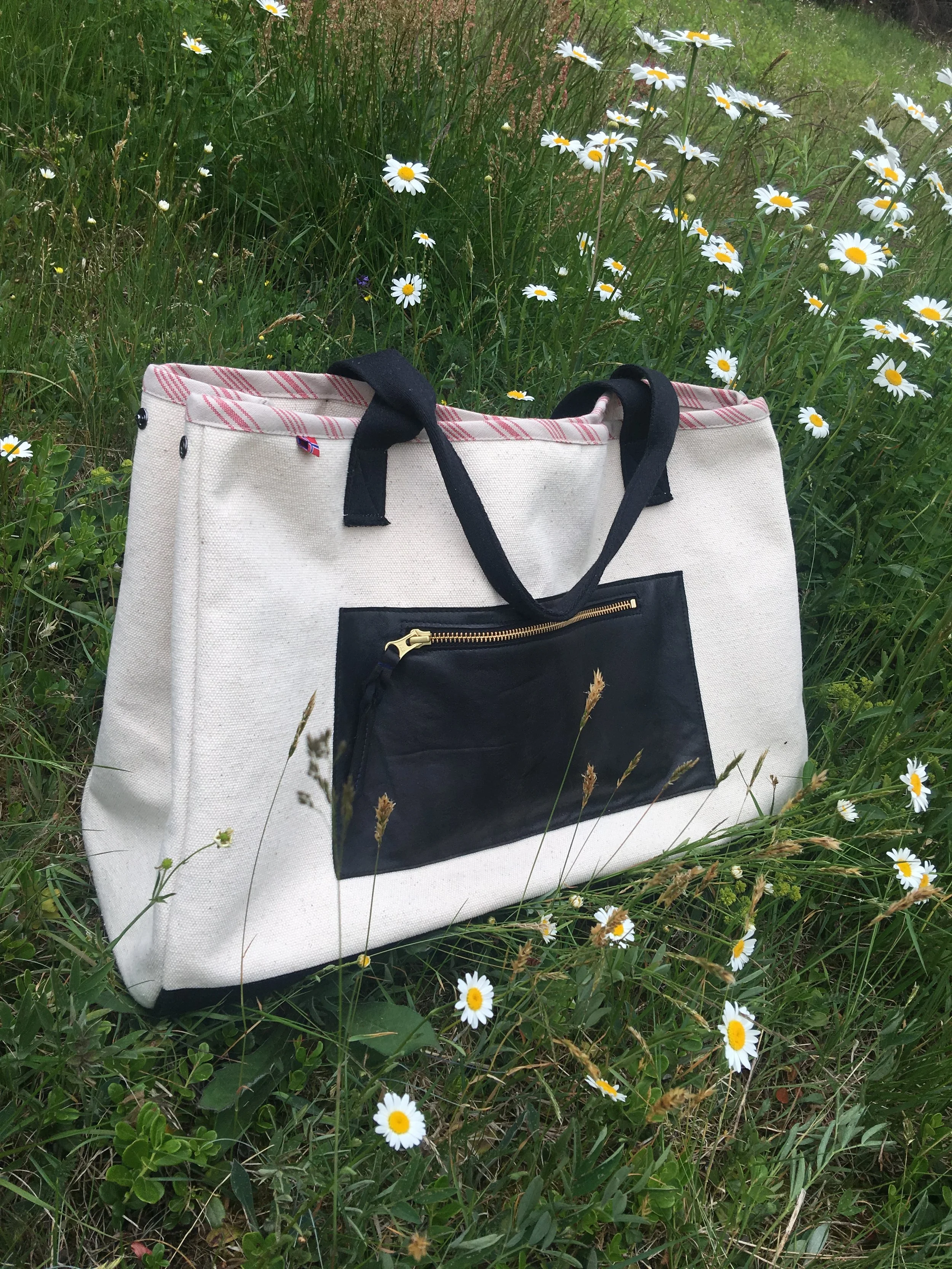 Canvas tote bag with a leather zip pocket.