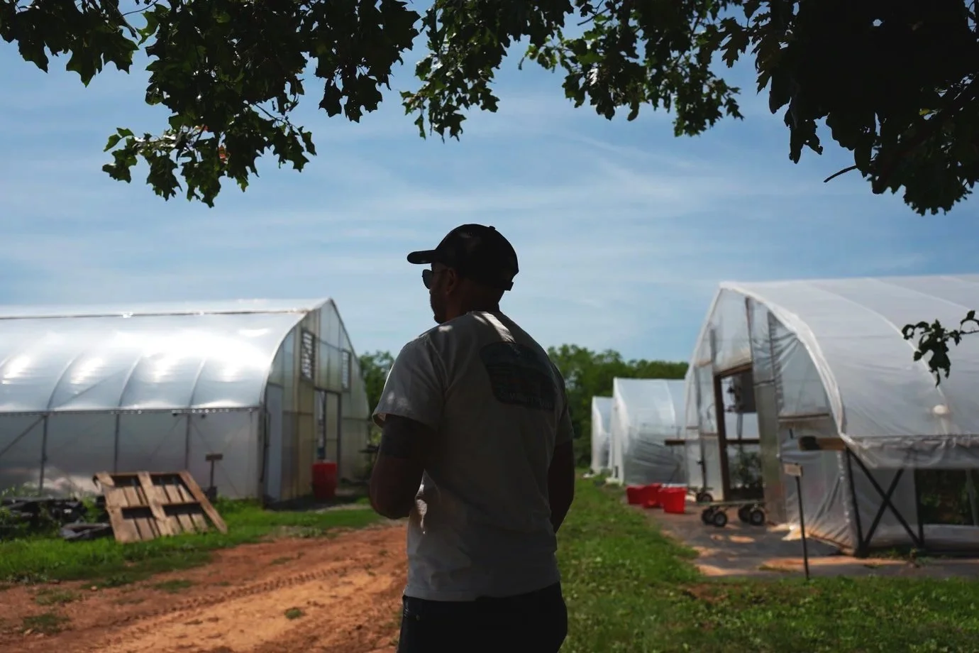  Ashish Kapoor, Piedmont Environmental Council’s senior energy and climate adviser, walks by hoop houses on the Roundabout farm that are solar powered. 