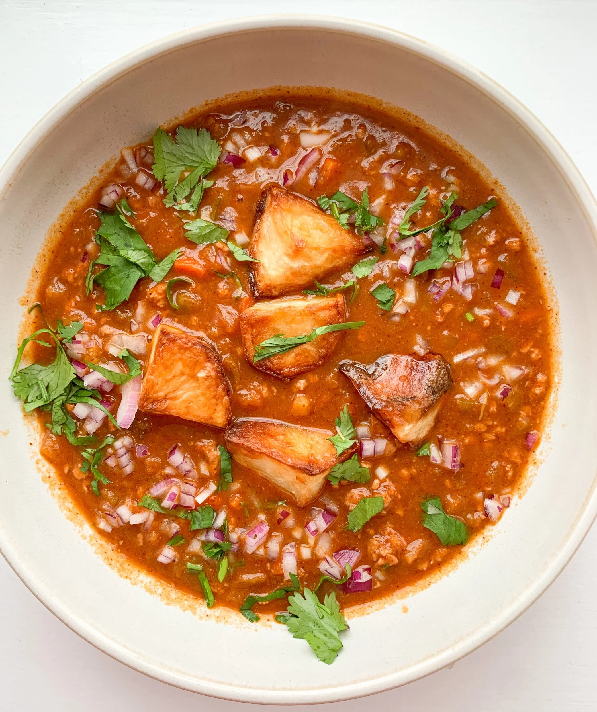 Garnished with crispy potatoes, red onion &amp; cilantro.