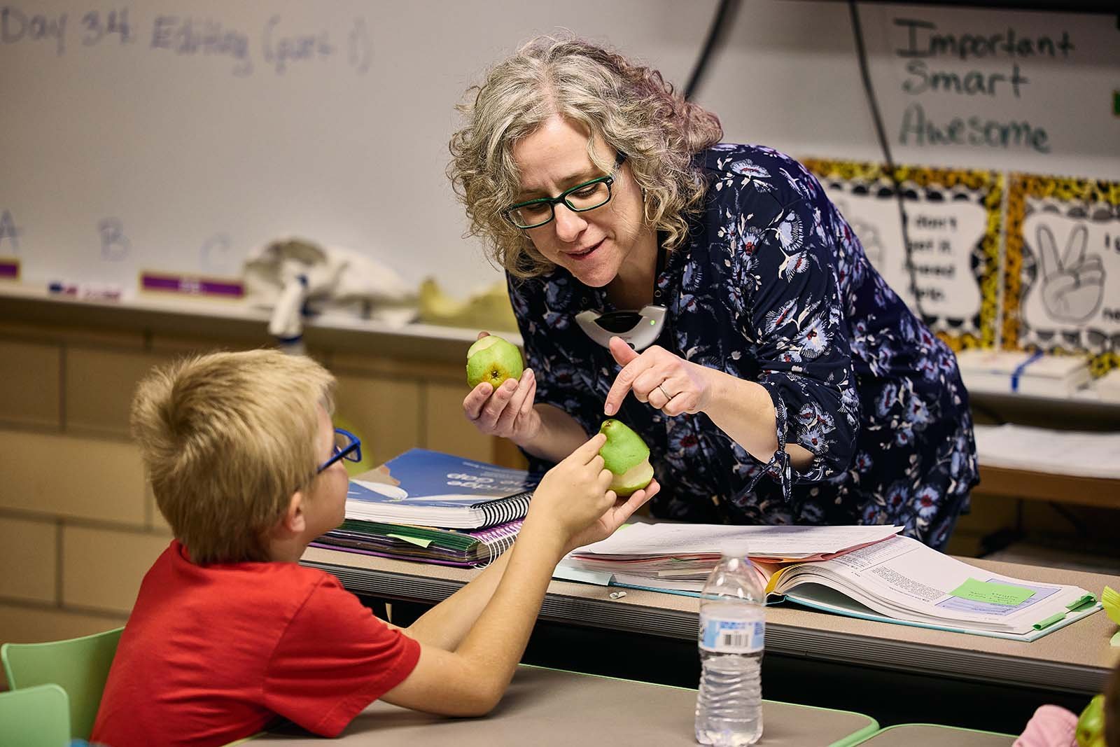  Second-grade teacher Janet Baker talks to a student about the different parts of pears during a weekly fresh food lesson. 