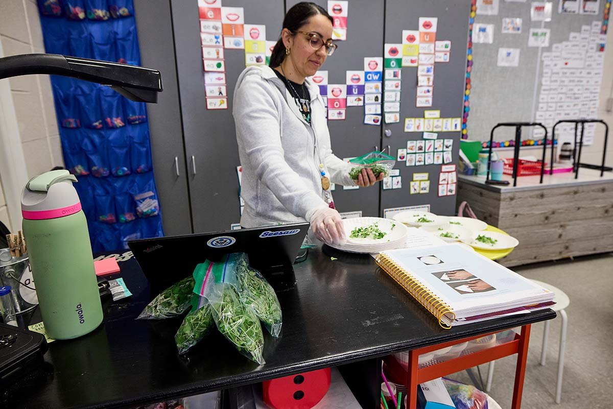 Jennifer Johnson, a 2nd grade teacher at Croninger Elementary School, serves students broccoli microgreens provided by local farms through the Harvest of the Month program.