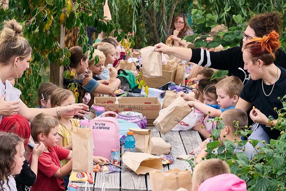 Students and teachers gather together for lunch in the Tinker Nook, a whimsically decorated garden space used for arts and crafts.