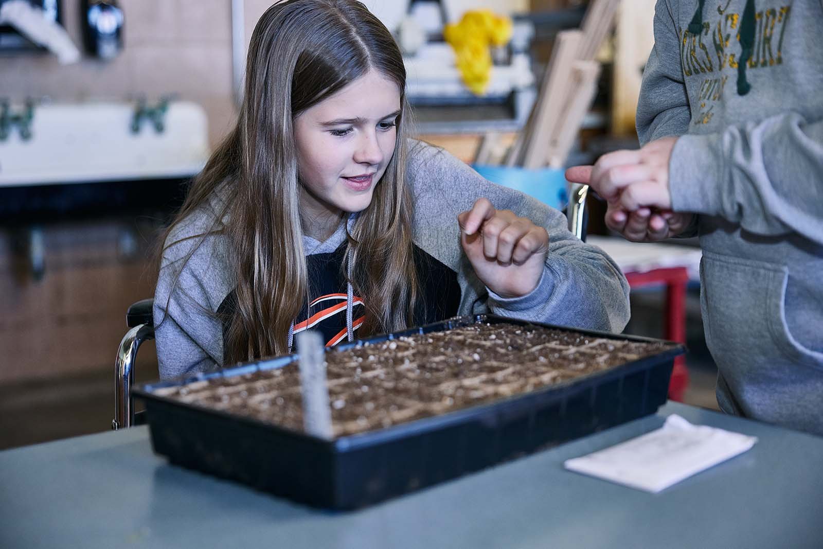  A sixth-grade student gets a hands-on lesson about seed starting during an agriculture class. 