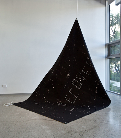 Recover , 2011, acrylic on unstretched canvas, metal eyelets, rope, 1800 x 3000mm (studio installation view).