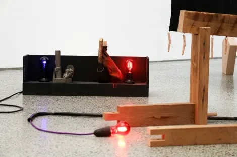  Installation view of  Old flames . 2025. Shelf light box and three components:  Hamish . 2010. Wood, cork, found bottle and gloves;  Old Flames . 2010. Clay, paint, plastic candle;  Old Raver . 2024. Anagama fired clay.&nbsp; 