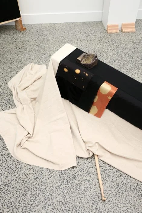  Installation view of  Treatment . 2025. Anagma fired clay, bisqued clay, canvas drop-cloth, silk, calico, velvet, thread, bench. Dimensions variable.  