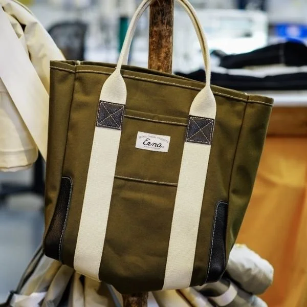 army green canvas tote bag with leather accents and leather corner reinforcements