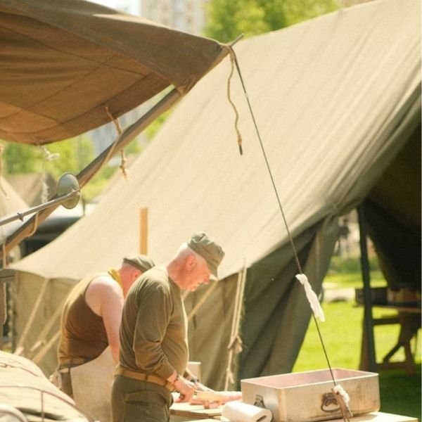 olive drab green canvas wall tent in military encampment