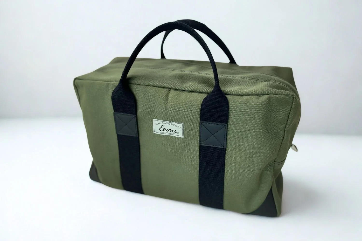 green duffel bag in white studio